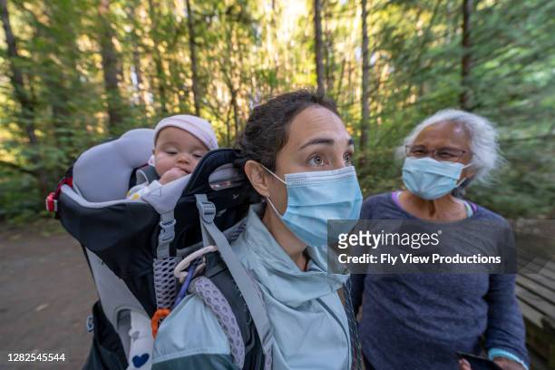 mixed race family wearing face masks hiking in the forest - washington coronavirus stock pictures, royalty-free photos & images