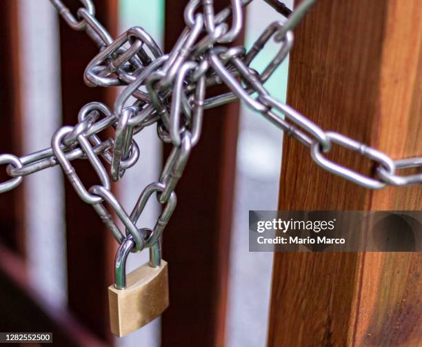 padlock and its chains - chain link fence on white stock-fotos und bilder