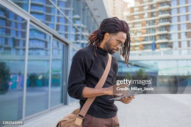 moderne afrikaanse amerikaanse zakenman die tablet voor bureaugebouw in openlucht gebruikt - dreadlocks stockfoto's en -beelden