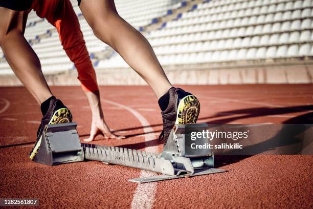 a young male sprint athlete at the start line in track and field. - track starting block stock pictures, royalty-free photos & images