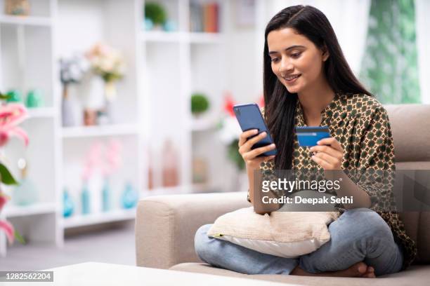 woman at home sofa sitting - stock photo - credit card stock pictures, royalty-free photos & images
