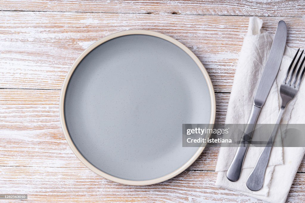 Empty ceramic plate on rural wooden background