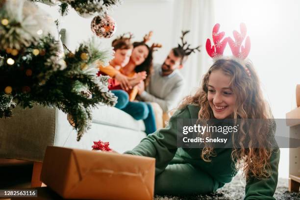 arranging the presents under the christmas tree - build presents the family stock pictures, royalty-free photos & images