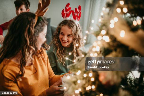 decorating christmas tree with your mum - family christmas tree stock pictures, royalty-free photos & images