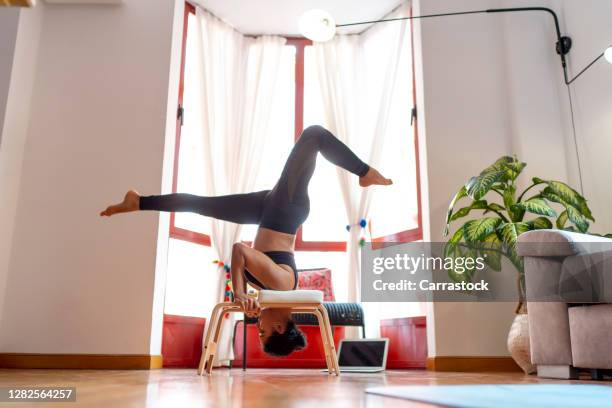 woman doing yoga exercises next to a computer. - upright position stock pictures, royalty-free photos & images