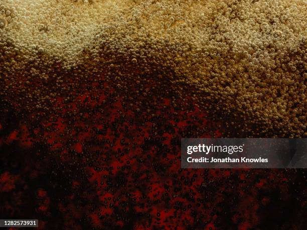 close up bubbles in liquid - bier dunkel stock-fotos und bilder