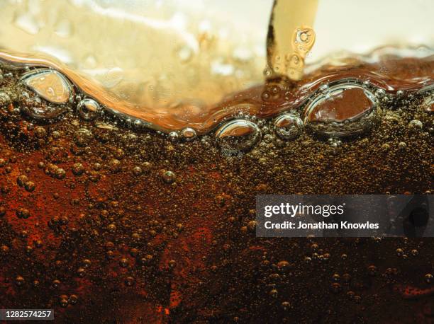 close up soda pour - cola stockfoto's en -beelden