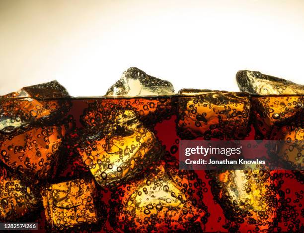 ice cubes in soda - cola stock-fotos und bilder