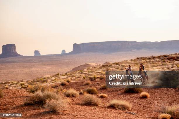 four young native american navajo brothers and sisters riding their horses bareback in the northern arizona monument valley tribal park at dusk together - horseback riding arizona stock pictures, royalty-free photos & images