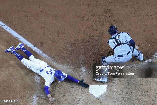 Mookie Betts of the Los Angeles Dodgers slides in safely past Mike Zunino of the Tampa Bay Rays to score a run on a fielders choice hit by Corey...