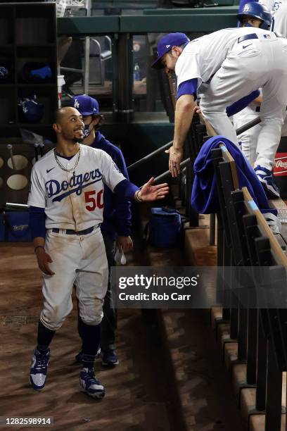 Mookie Betts of the Los Angeles Dodgers is congratulated by A.J. Pollock after hitting a solo home run against the Tampa Bay Rays during the eighth...