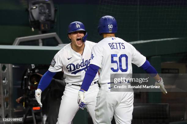 Mookie Betts of the Los Angeles Dodgers is congratulated by Enrique Hernandez after hitting a solo home run against the Tampa Bay Rays during the...