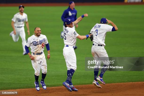 Chris Taylor, Cody Bellinger and Mookie Betts of the Los Angeles Dodgers celebrate after defeating the Tampa Bay Rays 3-1 in Game Six to win the 2020...