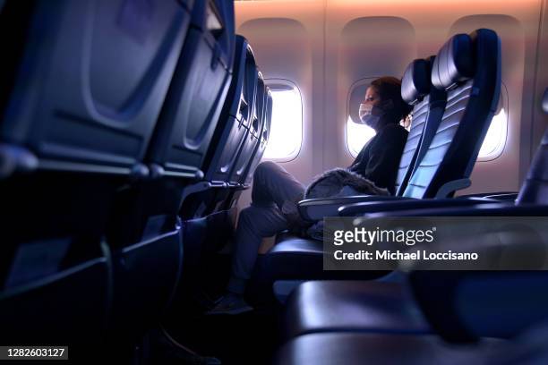 Masked passenger is seen seated on a flight from San Francisco, California to Newark, New Jersey on October 27, 2020. Although virus dissemination on...