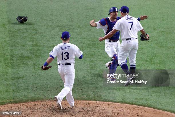 Julio Urias of the Los Angeles Dodgers celebrates with Austin Barnes after defeating the Tampa Bay Rays 3-1 in Game Six to win the 2020 MLB World...