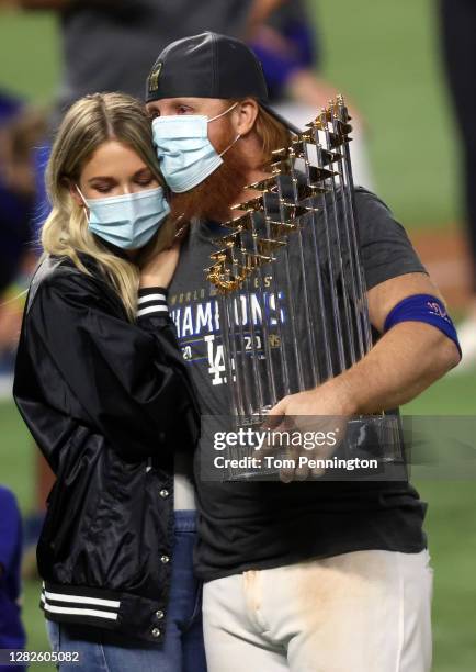 Justin Turner of the Los Angeles Dodgers and his wife Kourtney Pogue, hold the Commissioners Trophy after the teams 3-1 victory against the Tampa Bay...