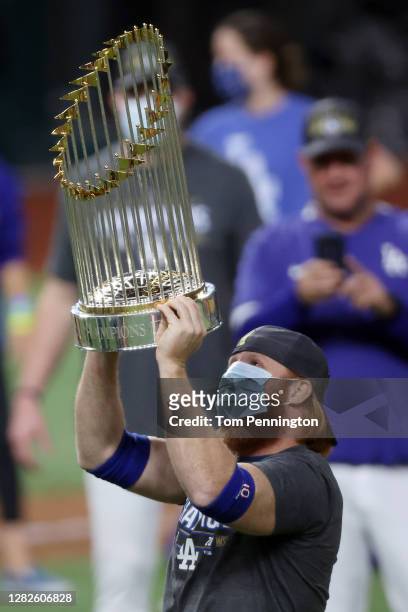 Justin Turner of the Los Angeles Dodgers celebrates with the Commissioner's Trophy after defeating the Tampa Bay Rays 3-1 in Game Six to win the 2020...