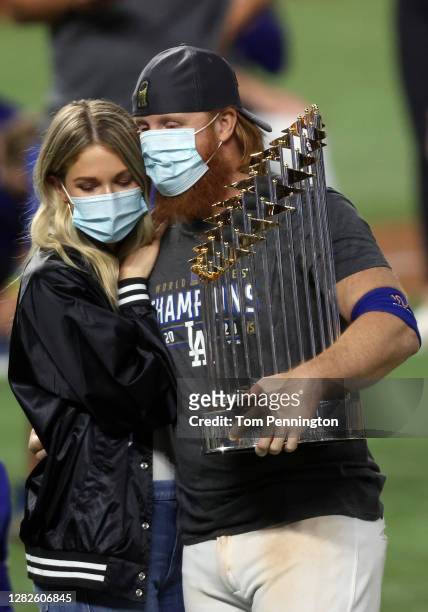 Justin Turner of the Los Angeles Dodgers and his wife Kourtney Pogue, hold the Commissioners Trophy after the teams 3-1 victory against the Tampa Bay...