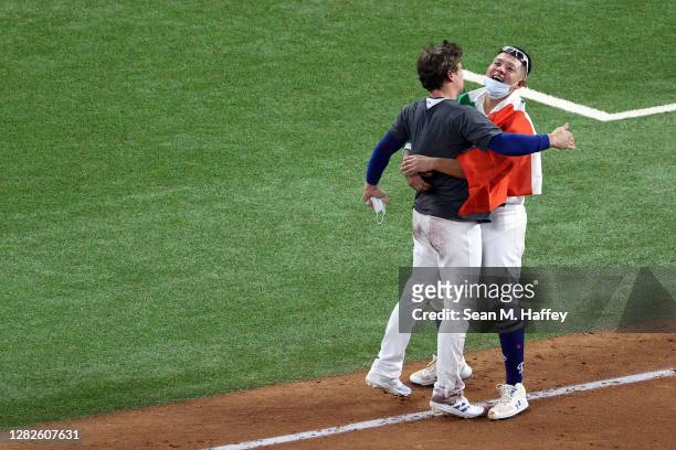 Julio Urías of the Los Angeles Dodgers celebrates with Enrique Hernandez after defeating the Tampa Bay Rays 3-1 in Game Six to win the 2020 MLB World...