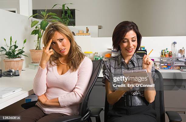 two employees in office cubicle - confused woman stockfoto's en -beelden