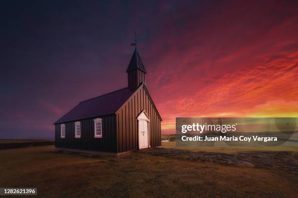 a dreamy sunset at the black church of budir, budir, golden circle route, snaefellsnes, iceland - christian kalt stock-fotos und bilder