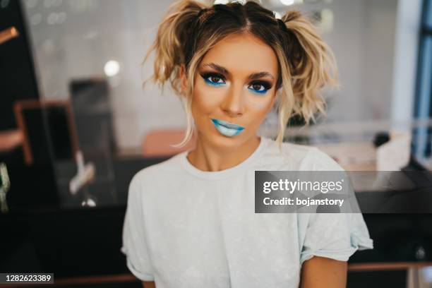 mujer joven en salón de belleza - pintalabios azul fotografías e imágenes de stock