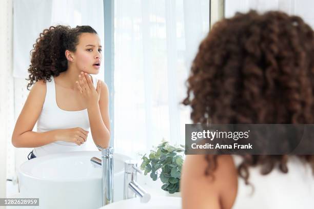 beautiful teenage girl checking out a new pimple - face irritation stock pictures, royalty-free photos & images