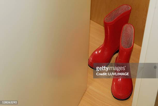 red children's rainboots in door opening - eversofine stock pictures, royalty-free photos & images