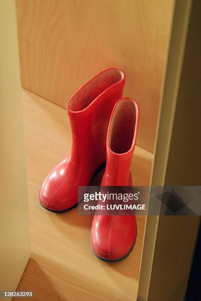 red children's rainboots in door opening - eversofine stock pictures, royalty-free photos & images