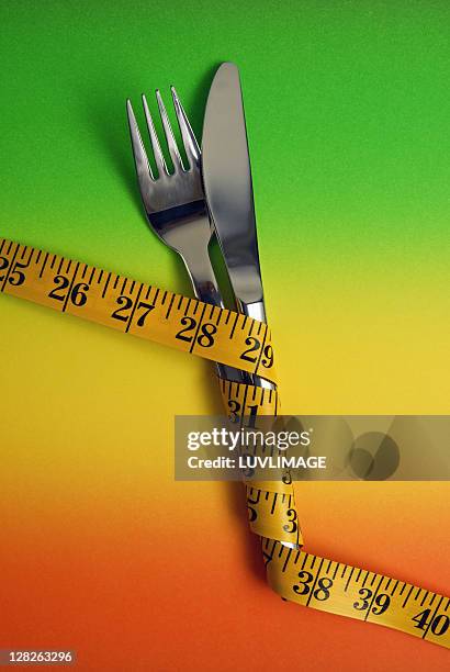 fork and knife wrapped in measuring tape - eversofine stock pictures, royalty-free photos & images