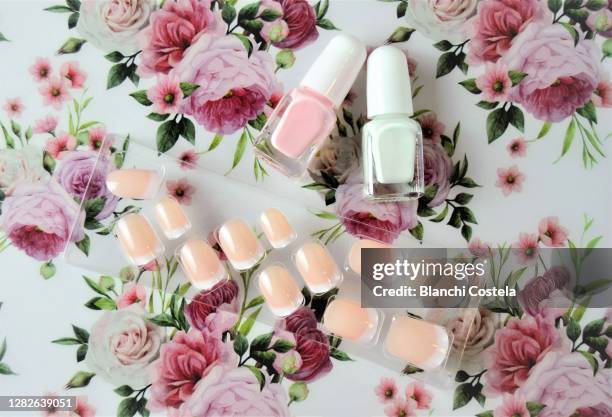 false nails and polishes on a flower background - acrylic nails stock pictures, royalty-free photos & images