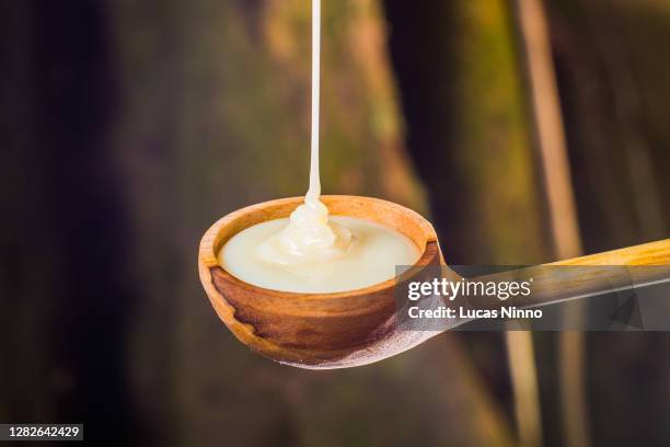 filling spoon with condensed milk - condensed milk stock pictures, royalty-free photos & images