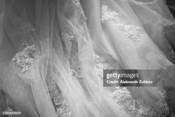 the hem of the white wedding openwork silk expensive luxury bride's dress. copy of the space. - dentelle en matière textile photos et images de collection
