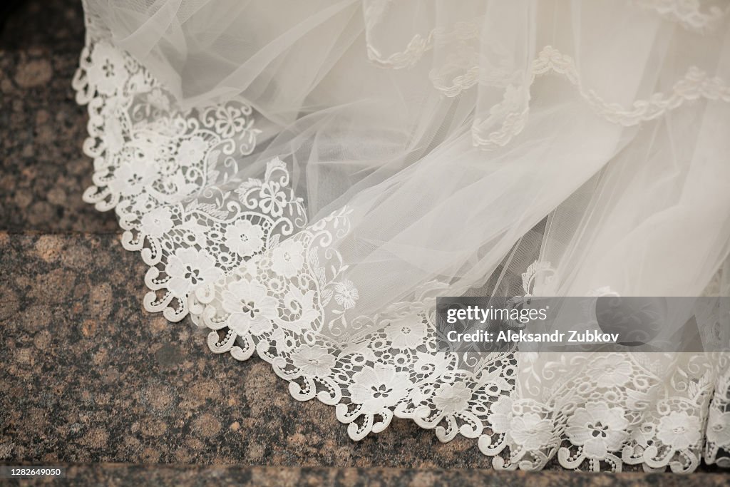 The hem of The white wedding openwork silk expensive luxury bride's dress. Copy of the space.