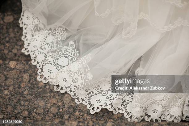 the hem of the white wedding openwork silk expensive luxury bride's dress. copy of the space. - hem foto e immagini stock