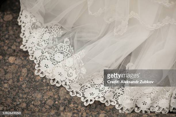 the hem of the white wedding openwork silk expensive luxury bride's dress. copy of the space. - kanten rok stockfoto's en -beelden