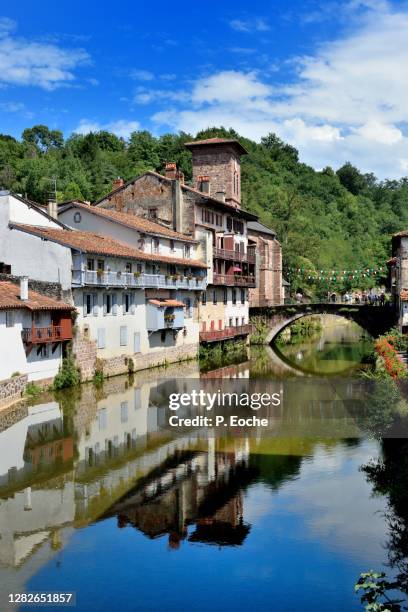 saint-jean-pied-de-port, the roman bridge over the nive of béhérobie and the church of l'assomption. - saint jean pied de port fotografías e imágenes de stock