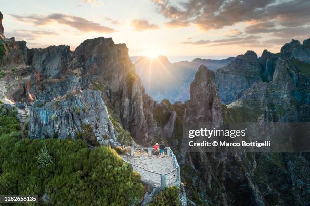 two people admiring sunset from pico do arieiro. madeira island, portugal - madeira stockfoto's en -beelden