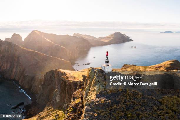 woman standing on top of a mountain admiring the view, madeira, portugal - 半島 ストックフォトと画像