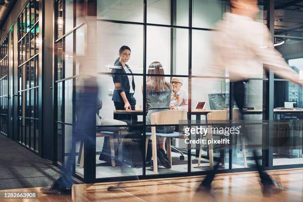 bedrijfspersonen die rond het bureaugebouw lopen en werken - beroep stockfoto's en -beelden