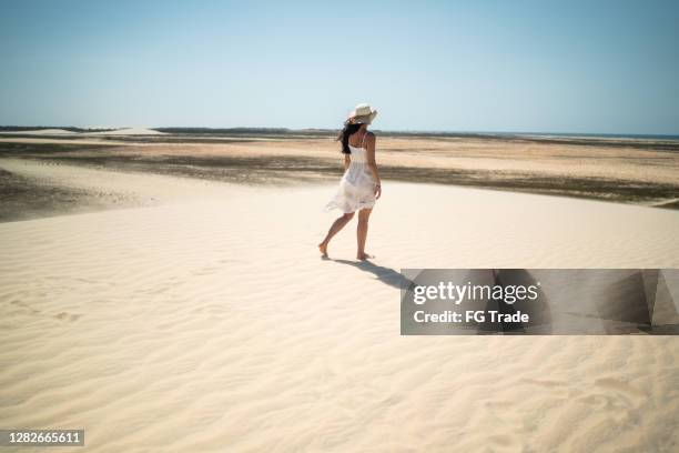 achtermening van een jonge vrouw die in zandduinen in jericoacoara loopt - jericoacoara stockfoto's en -beelden