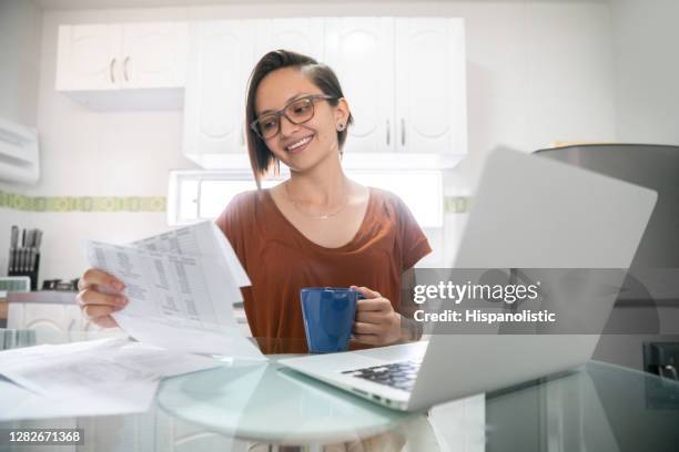 woman paying her bills online at home - energy bill stock pictures, royalty-free photos & images