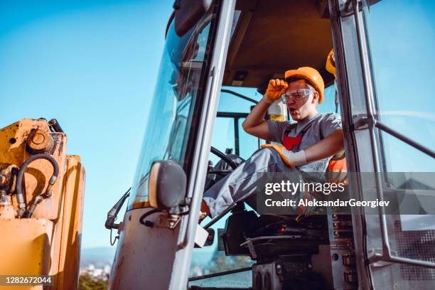 male bulldozer driver stressed after making a mistake - construction mistake stock pictures, royalty-free photos & images