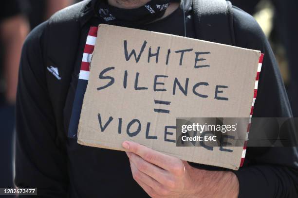 protestor holds sign at march and rally to protest police violence - anti racism stock pictures, royalty-free photos & images