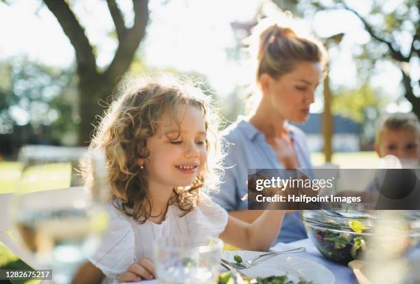 small girl with mother on outdoor summer garden party, eating. - roast chicken table stock pictures, royalty-free photos & images
