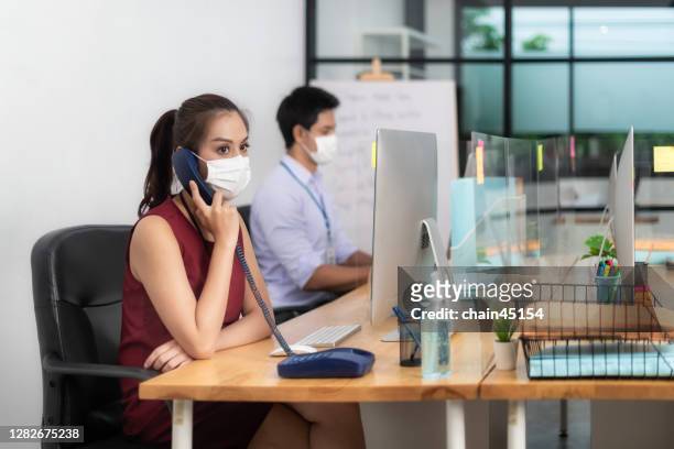 business office employee wear protective face mask for hygiene in new normal office with social distance practice prevent coronavirus covid-19 spreading. re-open office new normal concept. working meeting in business. - protective face mask office stock pictures, royalty-free photos & images