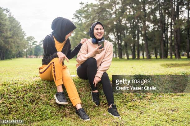 two girls talking and chating - indonesian girl stock pictures, royalty-free photos & images