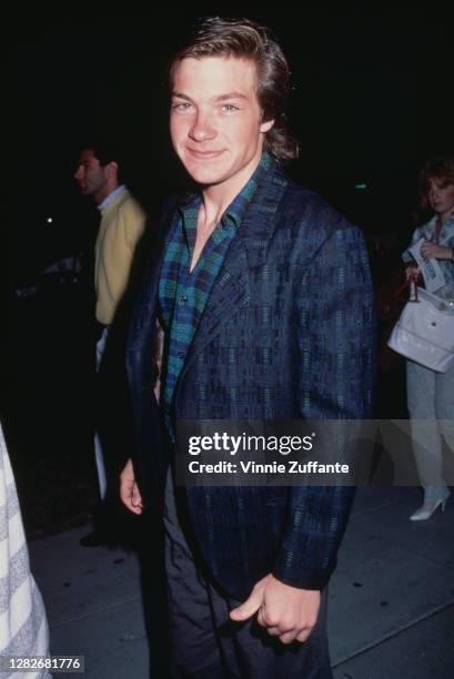 American actor Jason Bateman wearing a blue and green check shirt beneath a blue jacket, location unknown, circa 1990.