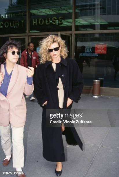 Woman walks with American actress Kim Basinger as she leaves Los Angeles Superior Court in Los Angeles, California, 1st March 1993. Basinger is being...