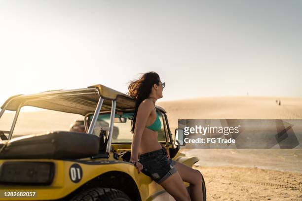 frau in einem buggy blickauf sicht in sanddünen in jericoacoara - horse carriage stock-fotos und bilder